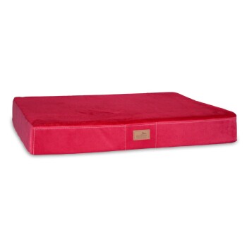 Rotes Haustierbett mit einer weichen Oberfläche und einem gesteppten Rand, mit einem kleinen Holzanhänger mit dem Markennamen.