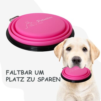 Pink zusammenklappbarer Haustiernapf mit schwarzem Rand, mit dem Text 'FALTBAR UM PLATZ ZU SPAREN' auf einem hellen Hintergrund.