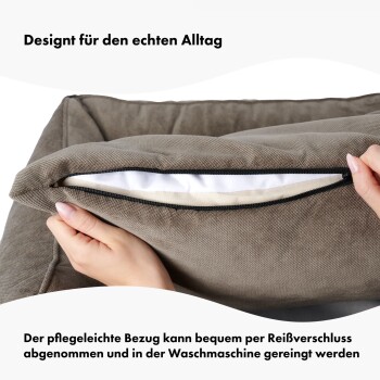 Haustierbett mit geöffnetem Bezug, gehalten von einer Hand. Text: "Pflegeleichter Bezug lässt sich über den Reißverschluss für die Maschinenwäsche entfernen."