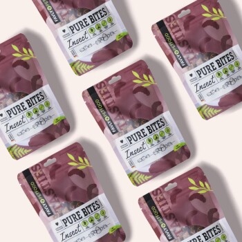 Sechs Pakete von "Pure Bites Insect" Haustierleckerlis werden angezeigt, mit einem lila Design und grünen Akzenten sowie Illustrationen von Insekten.