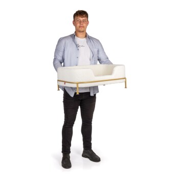 Eine Person hält ein stilvolles weißes Haustierbett mit einem goldenen Rahmen, das modernes Design und Komfort für Haustiere zeigt.