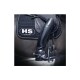 Eine Nahaufnahme des Beins eines Reiters in eleganten schwarzen Reitstiefeln, das an der Seite eines Pferdes ruht, mit einem gesteppten Sattelpad mit 'HS GERMANY' Logo.