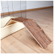 Holzrampe, die in einen kleinen Haustierkäfig führt, mit einer strukturierten Rinde-Oberfläche, auf einem hellen Holzboden.