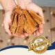 Zwei Schalen gefüllt mit Hundeleckerlis, eine gelbe und eine grüne, neben einem geknoteten Seilspielzeug auf einer Juteschicht.