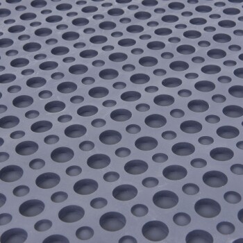 Nahaufnahme einer strukturierten Gummimatte mit zahlreichen gleichmäßig verteilten runden Löchern, ideal für die Pflege oder das Baden von Haustieren.