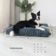 Ein schwarz-weißer Border Collie ruht auf einem plüschigen blauen Hundebett neben einer Pflanze, mit einer Größentabelle "Größentabelle" darunter.