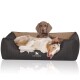 Ein gemütliches Hundebett in Schwarz und Beige mit einem Hund, der bequem liegt, mit dem Markennamen "KNUFFELWUFF" deutlich sichtbar.