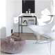 Ein gemütliches, flauschiges Haustierbett in einem modernen Wohnzimmer, mit einem kleinen Hund, der darin ruht. Ein eleganter schwarzer Beistelltisch hält dekorative Gegenstände und Bücher.