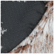 Close-up van een bruin-witte nepvacht huisdierdeken met een zwarte antislip stippen achterkant.
