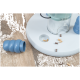 Interaktiver Futterspender mit blauem Puzzle-Spielzeug und verstreuten kleinen, knochenförmigen Leckerlis auf Holzboden.
