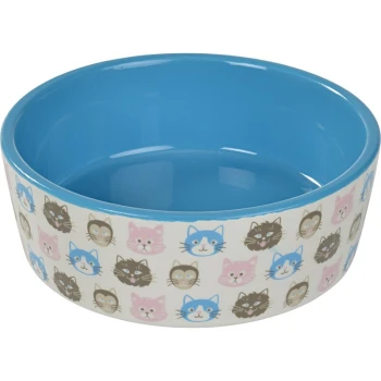 Bol en céramique pour nourriture de chat avec un intérieur bleu et un extérieur décoratif présentant divers visages de chats en cartoon en rose, bleu et noir.