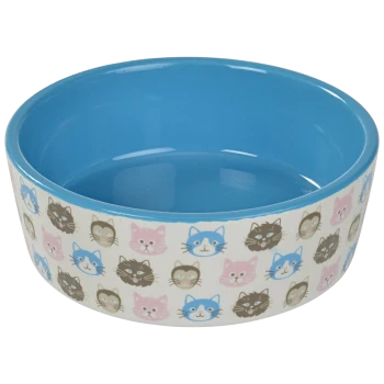 Keramischer Katzenfutterschüssel mit blauem Innenraum und dekorativem Äußeren, das verschiedene Cartoon-Katzenköpfe in Pink, Blau und Schwarz zeigt.