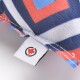 Nahaufnahme eines bunten Haustierspielzeugs mit geometrischem Muster in Rot, Blau und Weiß, mit einem Etikett, das ein kanadisches Ahornblatt-Logo zeigt.