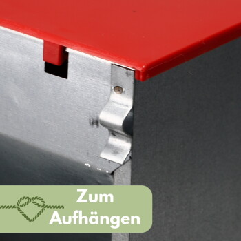 Nahaufnahme einer Metallkistenecke mit rotem Deckel und Metallaufhänger; grünes Label mit Seilsymbol: 'Zum Aufhängen'.