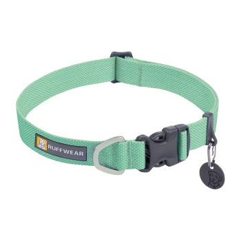 Ein grüner Hundehalsband von Ruffwear mit einer stabilen Schnalle, einem Metall-D-Ring zur Leinenbefestigung und einem Anhänger mit einem Hundelogo.