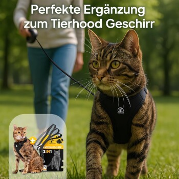 Eine getigerte Katze, die ein schwarzes Geschirr trägt, läuft auf Gras, während eine Person eine Leine hält. Text lautet: 'Perfekte Ergänzung zum Tierhood Geschirr.'