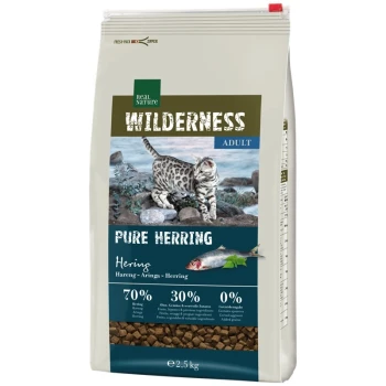 Tüte Real Nature Wilderness Katzenfutter, "Pure Hering," mit einer gescheckten Katze auf Felsen. 70% Hering, 30% Früchte/Gemüse, 0% Getreide.