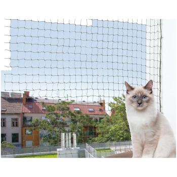 Kot siedzi na balkonie z zamontowaną siatką zabezpieczającą, z widokiem na miejską panoramę z budynkami i drzewami w tle.