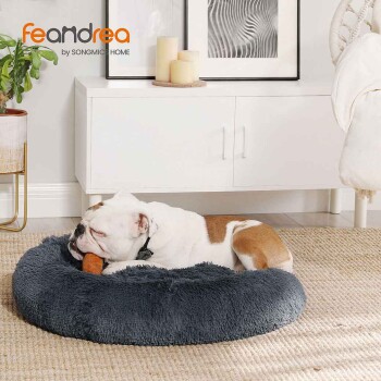 Bulldogge schläft auf rundem grauem Plüschhundebett mit orangefarbenem Spielzeug; Markenbezeichnung 'feandrea by SONGMICS HOME' sichtbar.