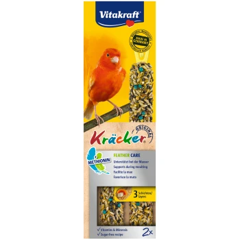 Ein leuchtend orangefarbener Kanarienvogel sitzt neben Vitakraft Kräcker Leckereien auf einem gelben Hintergrund mit den Texten "Federpflege" und "Vitamine & Mineralien".
