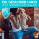 Eine Frau mit Tattoos hält einen kleinen Hund, während sie ihn küsst, vor einer Ziegelmauer. Der Text lautet "Ein gesunder Hund" und "LFGB geprüfte Materialien."