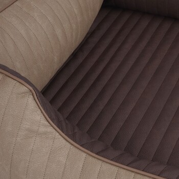 Eine Nahaufnahme eines Haustierbettes mit einem beigen, strukturierten Äußeren mit vertikalen Streifen und einem dunkelbraunen, gerippten Inneren.