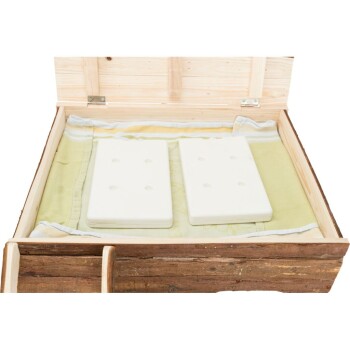 Holzhaustierbett mit offenem Deckel, mit zwei weißen Schaumstoffpolstern auf einem grünen Handtuch im Inneren.