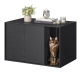 Schwarzer Holzschrank mit einer getigerten Katze, die in einem offenen Fach sitzt, oben Bücher, eine Uhr, Kerzen und eine Blumenvase.