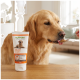 Golden Retriever leckt von einem Löffel gefütterte Paste neben einer Tube mit der Aufschrift SUPPORT Optimize & Care VITAL PASTE 200 g auf einem Holztisch.