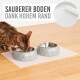Eine Bengal-Katze frisst aus zwei grauen geometrischen Haustierschalen auf einer weißen Matte, mit dem Text "SAUBERER BODEN DANK HOHEM RAND" darüber.