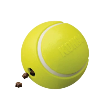 A bright yellow KONG dog toy shaped like a tennis ball, with small treats spilling out from a hole on the side.