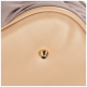 Close-up of a beige pet carrier bottom with a gold metal protective stud and taupe fabric edge.