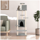 Ein hoher, grauer Katzenbaum mit mehreren Plattformen und einem gemütlichen Versteck, mit einer getigerten Katze oben, neben einem grünen Sofa und einer Topfpflanze.