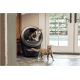 Zwei Katzen in einem modernen Wohnambiente; eine dreifarbige Katze sitzt in einer eleganten schwarzen Katzentoilette, während eine getigerte Katze in der Nähe läuft.