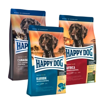Drei Beutel Happy Dog-Hundefutter, beschriftet mit "Kanada", "Karibik" und "Afrika", mit einem Hundebild und Nährwertangaben.