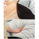 Eine Nahaufnahme eines plüschigen Haustierbettes mit schwarzem Außenmaterial und weichem grauem Innenfutter, mit einer Hand, die sanft in den Stoff drückt.