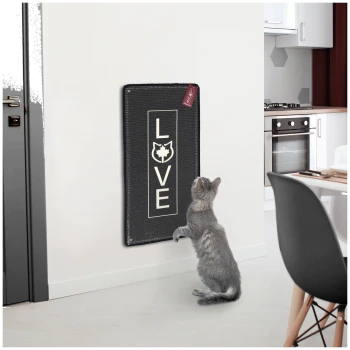 Eine graue Katze steht auf ihren Hinterbeinen und greift nach einem wandmontierten Kratzbrett, das das Wort "LIEBE" in fetten Buchstaben zeigt.
