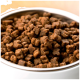 Eine Nahaufnahme einer Schüssel, gefüllt mit kleinen, braunen, kibbleförmigen Tierfutterstücken, die kleinen Knochen und Quadraten ähneln.