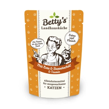 Die Verpackung von Betty's Landhausküche Katzenfutter zeigt einen Koch, eine Katze und den Text: "Mit Ente & Borretschöl & Taurin" für erwachsene Katzen.
