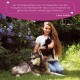 Frau hält eine schwarze Katze, neben ihr ein Husky; ein violettes Banner zeigt ein deutsches Zitat über Wolfsbacher Natur, Lena Huber.