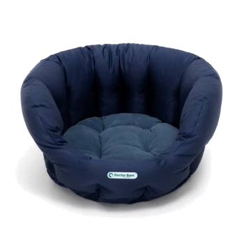 Marineblaues Haustierbett mit einem plüschigen, gesteppten Design und runder Form, mit einem kleinen "Doctor Bark"-Logo.