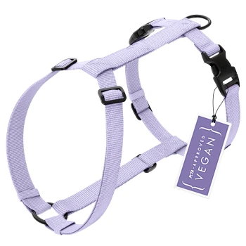 Ein lavendelfarbenes Haustiergeschirr mit schwarzen Clips und verstellbaren Riemen, mit einem Etikett, das "PETA Approved Vegan" liest.