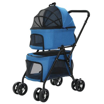 Ein kleiner weißer Hund sitzt bequem in einem blauen Haustierwagen mit einem oberen Fach und einem unteren Stauraum, mit Netzpaneelen und schwarzen Rädern.
