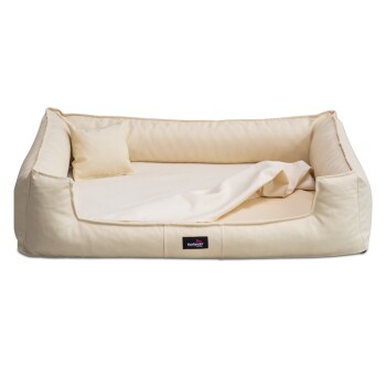 Ein plüschiges, cremefarbenes Haustierbett mit erhöhten Seiten und einem kleinen Kissen, mit einem schwarzen Etikett, das "tierlindz" trägt.