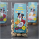 Verpackung von "Kokos Crunchies" Hundeleckerlis mit einem glücklichen Hund auf der Vorderseite, mit Bildern von Kokosnüssen, Fleisch und Aprikosen.