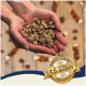 Hände halten braune Futterstücke für Haustiere, goldenes Abzeichen mit der Aufschrift 'Bewährte Qualität • Seit über 15 Jahren • Best Quality'.