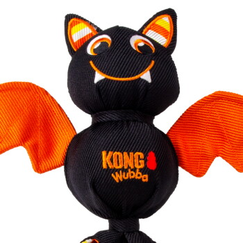 Black and orange bat-shaped KONG Wubba dog toy with smiling embroidered face, fangs, striped ears and orange wings.