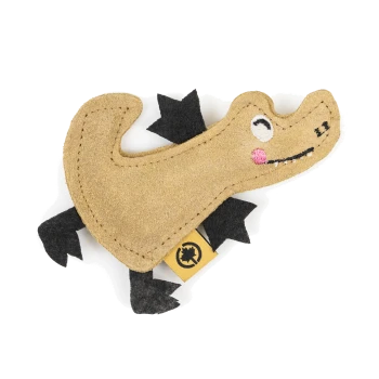 Ein niedliches, plüschiges Hundespielzeug in Form eines Alligators in Beige und Schwarz, mit gestickten Augen und einer rosa Wange, mit einem gelben Etikett.