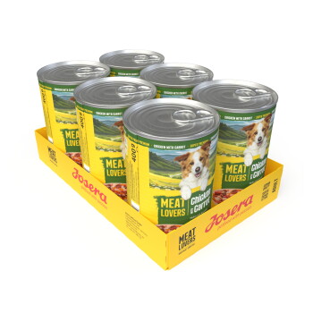 Sechs Josera Meat Lovers Hundefutterdosen (Chicken with Carrot) in gelbem Tray, Etiketten zeigen ein Hundefoto und den Schriftzug 'MEAT LOVERS'.