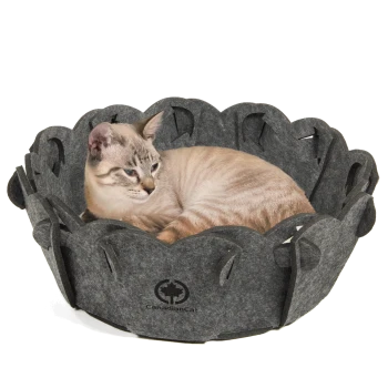 Eine hellfarbige Katze, die in einem dunkelgrauen Filz-Haustierbett in Blumenform liegt, mit dem Logo 'CanadianCat', das an der Seite sichtbar ist.